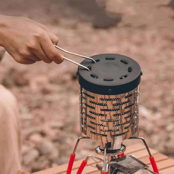 Une personne ajuste un chauffe-eau à gaz portable en acier inoxydable lors d'un voyage de camping en plein air.